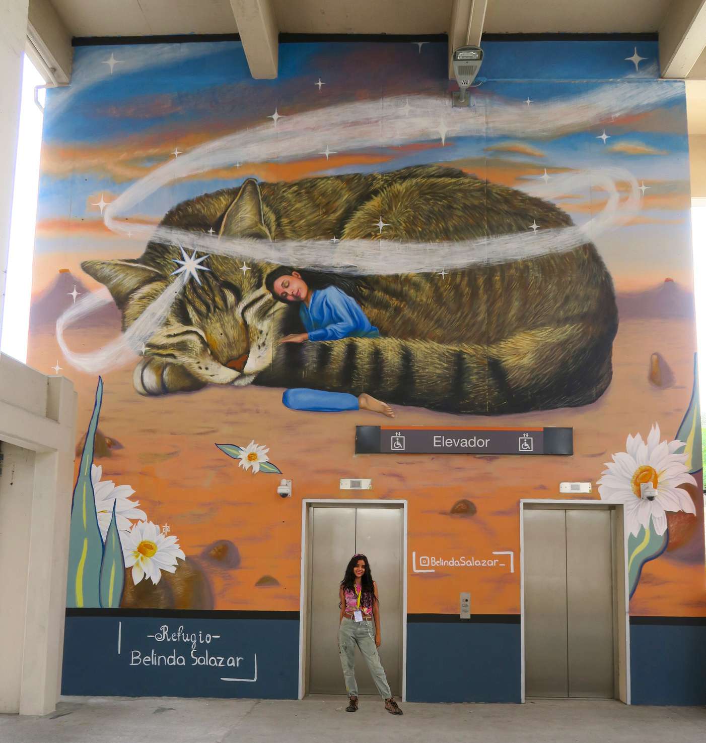 Mural Refugio de Belinda Salazar en la estación Hospital Metropolitano del Metro de Monterrey, una mujer dormida entre un gato gigante